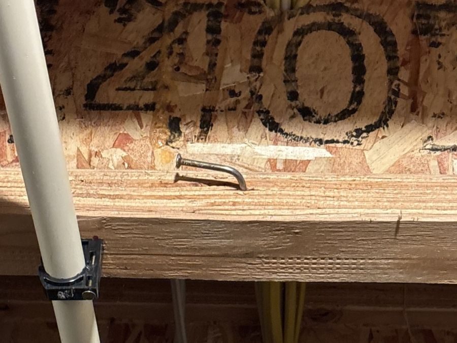 Bent nail driven through the top flange of an engineered wood I-joist